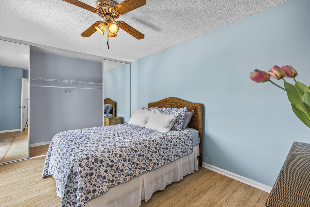 6025 Southeast Riverboat Drive, Unit 811 Stuart, FL 34997 - Photo 28 of 37 a bedroom with a bed and a chandelier