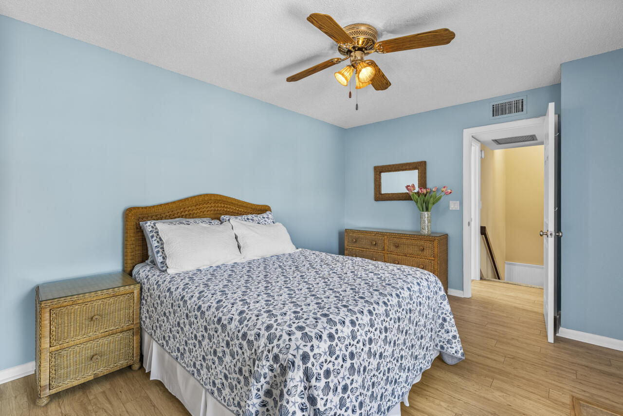 6025 Southeast Riverboat Drive, Unit 811 Stuart, FL 34997 - Photo 30 of 37 a bedroom with a bed and wooden floor