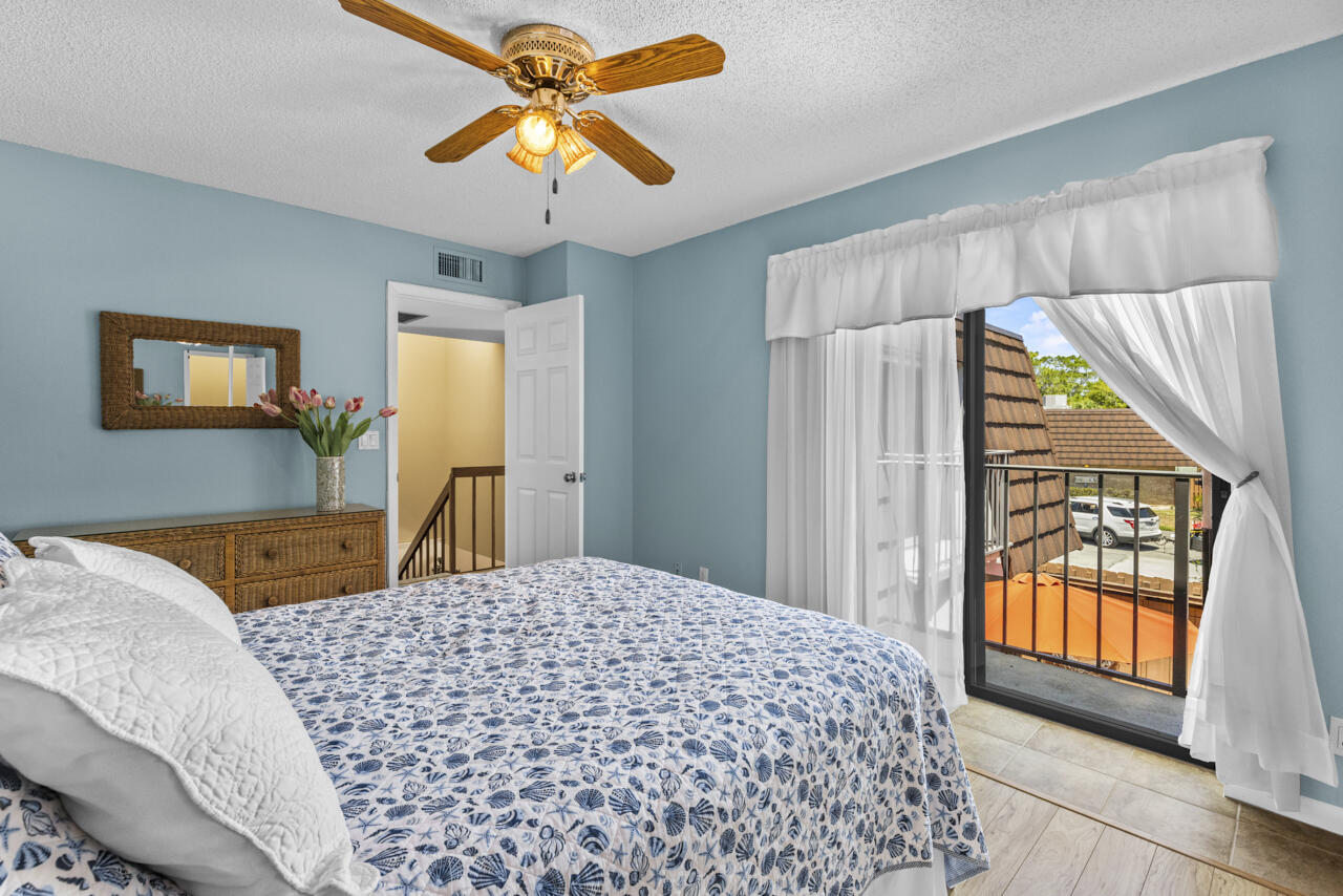 6025 Southeast Riverboat Drive, Unit 811 Stuart, FL 34997 - Photo 31 of 37 a bedroom with a bed and a chandelier