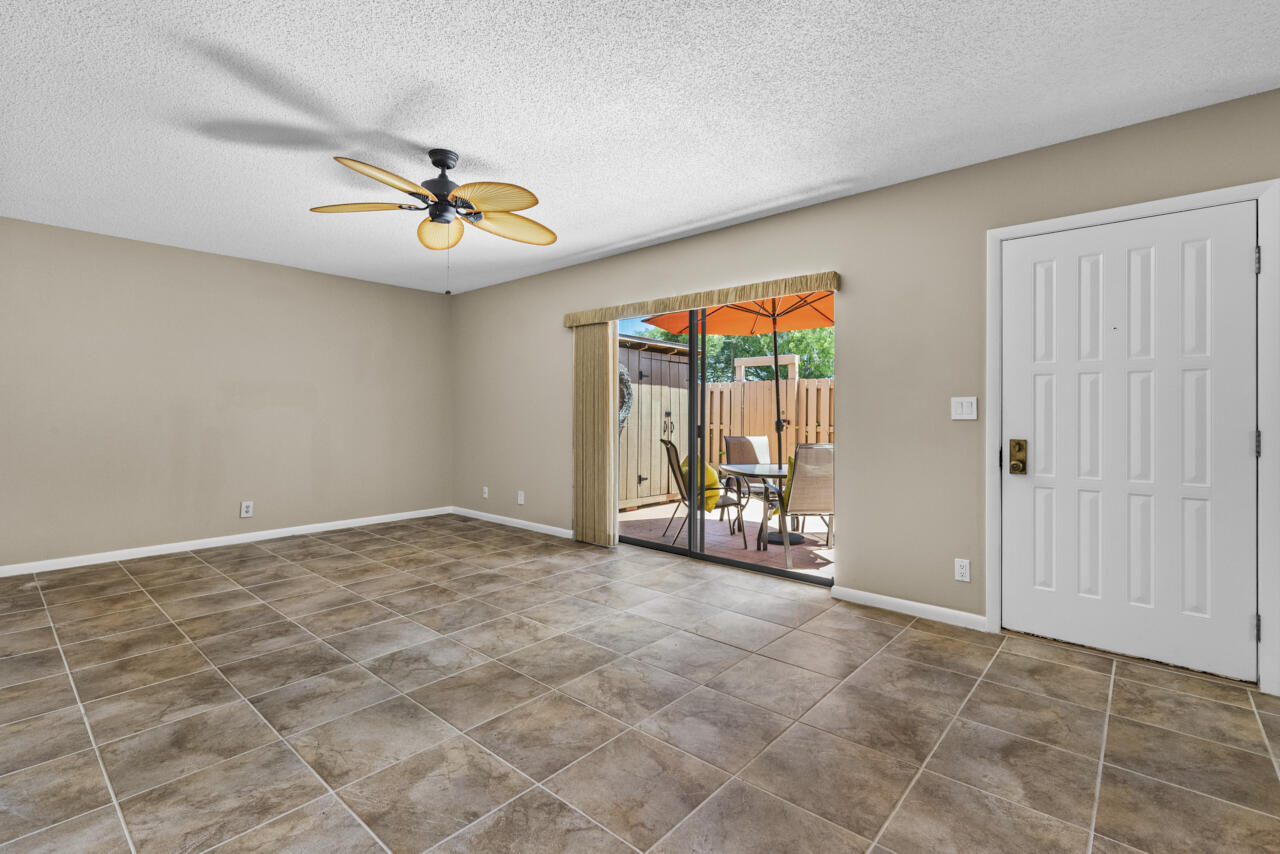 6025 Southeast Riverboat Drive, Unit 811 Stuart, FL 34997 - Photo 8 of 37 an empty room with windows and chandelier fan