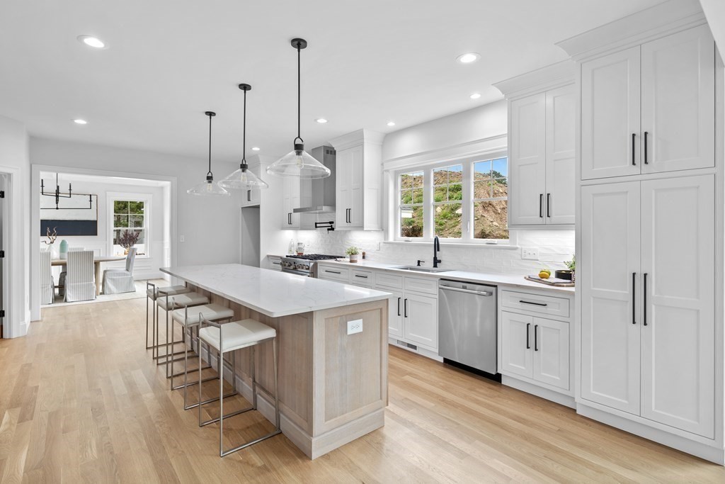 6 Rowell Road Middleton, MA 01949 - Photo 4 of 35 a kitchen with stainless steel appliances granite countertop a stove a sink dishwasher a refrigerator and white cabinets with wooden floor