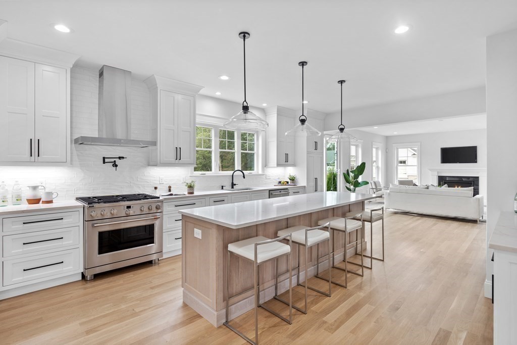 6 Rowell Road Middleton, MA 01949 - Photo 6 of 35 a kitchen with stainless steel appliances granite countertop a stove a sink dishwasher a refrigerator and a dining table with wooden floor