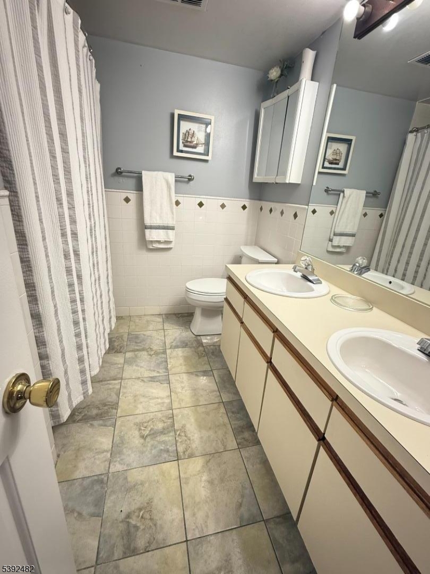 751 Summer Avenue, Unit 3A Newark, NJ 07104 - Photo 9 of 15 a bathroom with a sink a toilet and a mirror