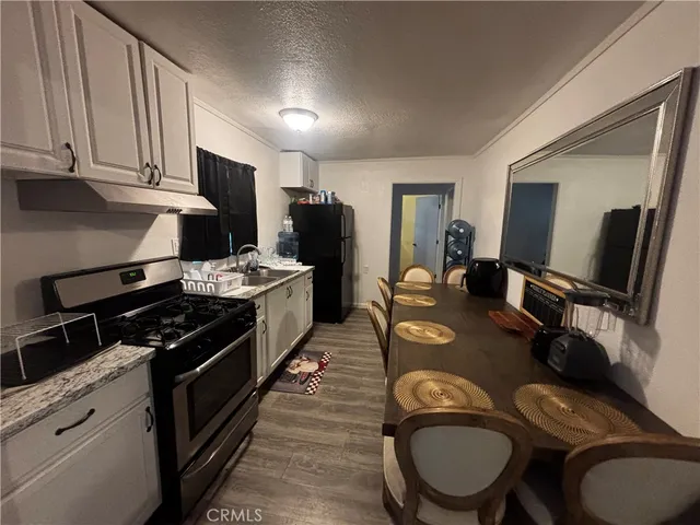 a kitchen with sink a stove and chairs