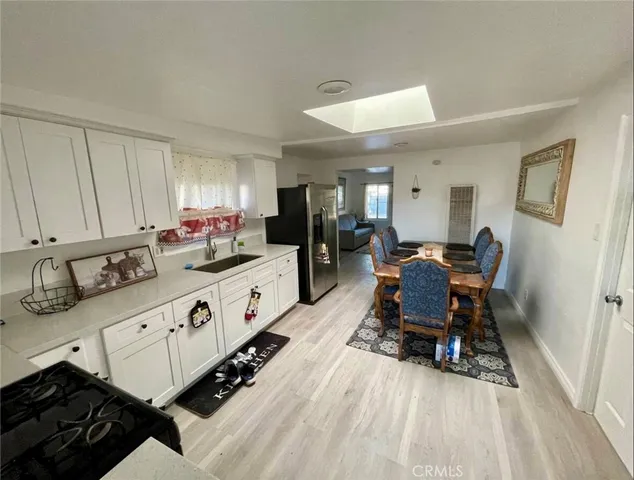 a large white kitchen with sink and chairs