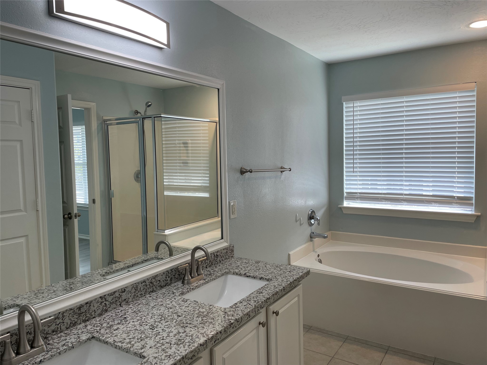 9022 Elm Drake Lane Humble, TX 77338 - Photo 11 of 17 a bathroom with a granite countertop tub sink and mirror