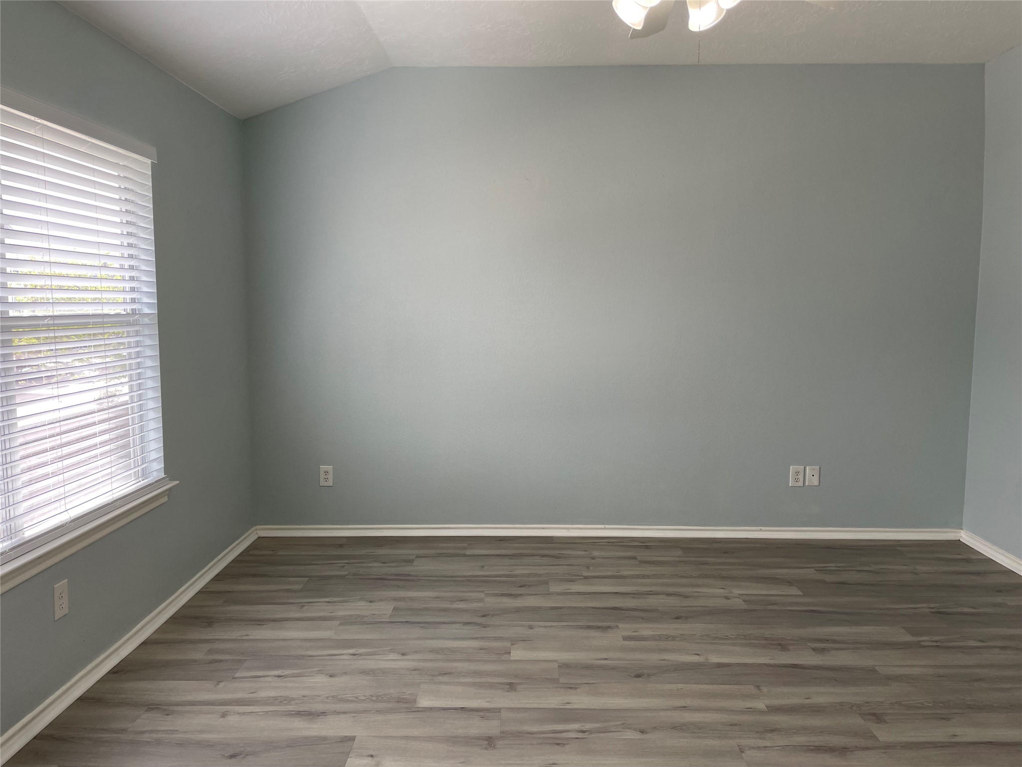 9022 Elm Drake Lane Humble, TX 77338 - Photo 10 of 17 a view of an empty room with wooden floor and a window