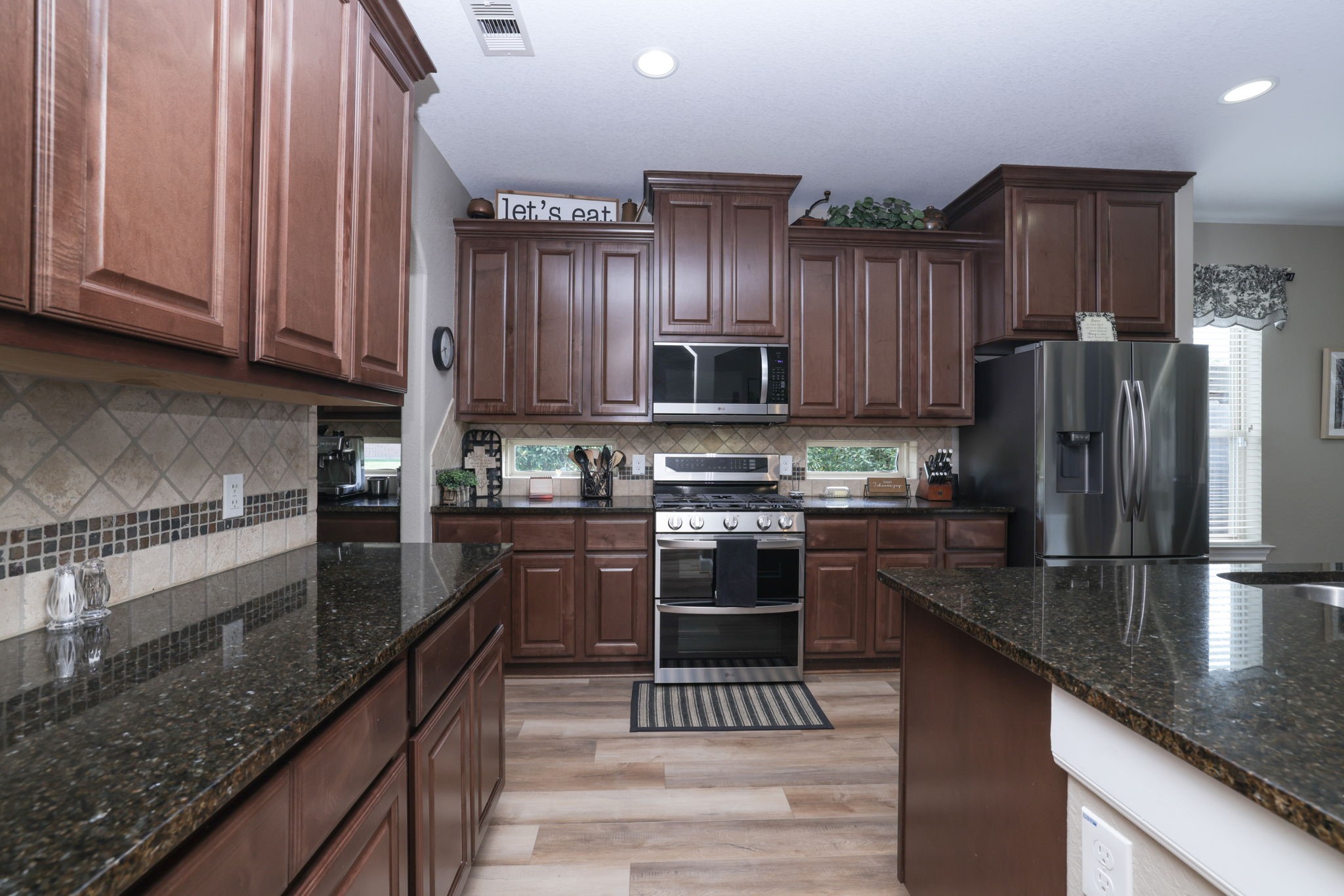 5922 Glen Lief Court Spring, TX 77379 - Photo 11 of 41 a kitchen with stainless steel appliances granite countertop a sink a stove and a refrigerator