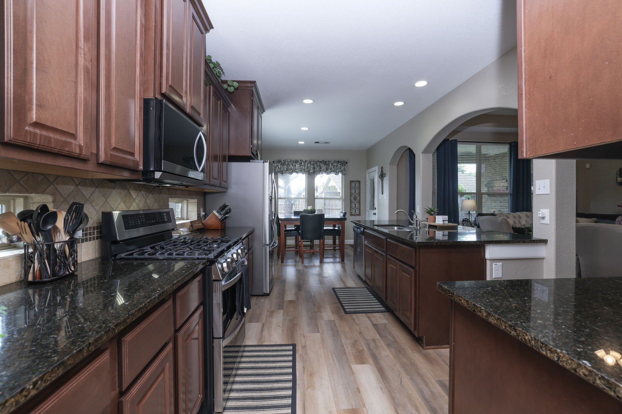 5922 Glen Lief Court Spring, TX 77379 - Photo 13 of 41 a kitchen with stainless steel appliances granite countertop sink stove top oven and cabinets