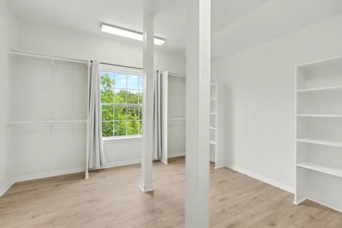 an empty room with windows and closet
