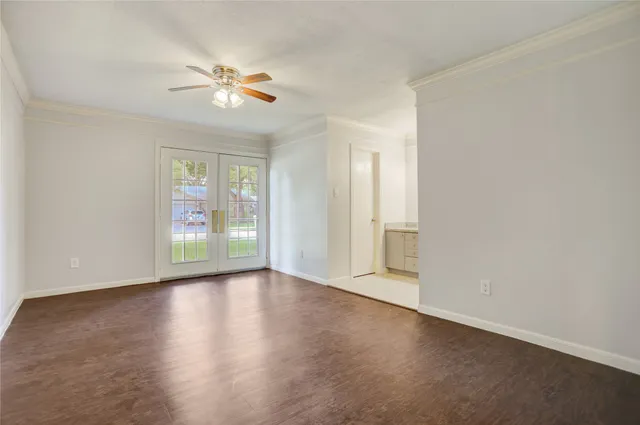a view of an empty room with a window and wooden floor
