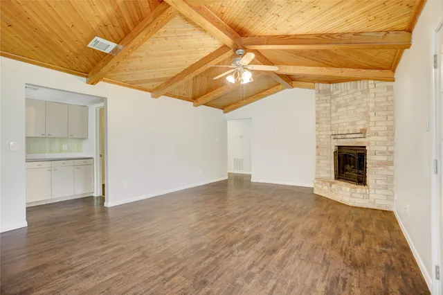 a view of empty room with wooden floor and fireplace