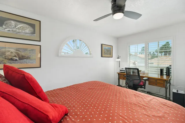 a bedroom with a bed and painting on the wall