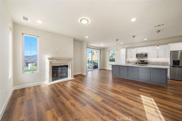 a view of kitchen with kitchen island wooden floor and living room