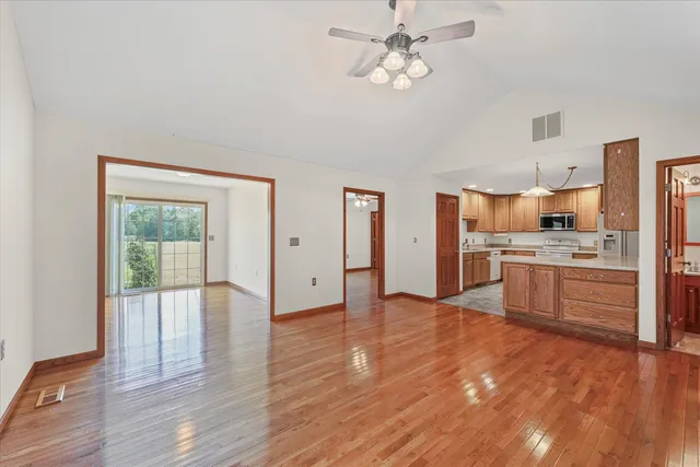 a large kitchen with stainless steel appliances a large counter top a sink and a refrigerator