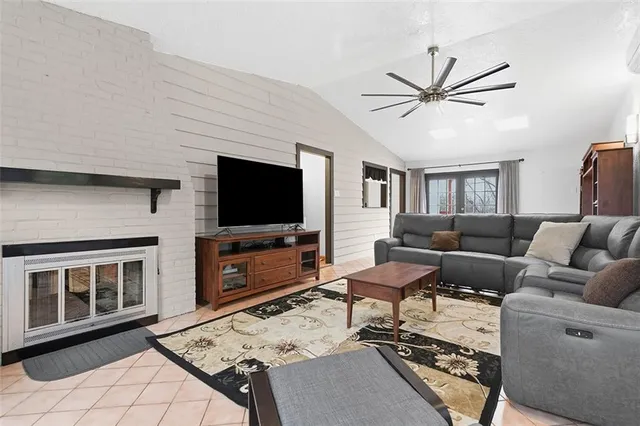 a living room with furniture a flat screen tv and a table