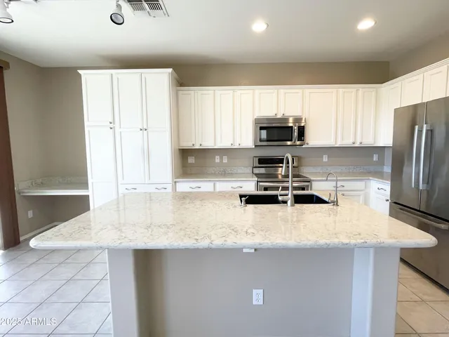 a kitchen with granite countertop a stove a sink a refrigerator and a granite counter tops