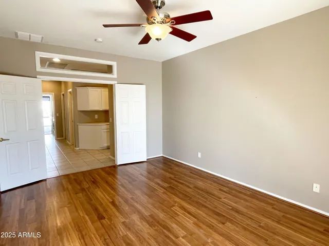 a view of empty room with wooden floor