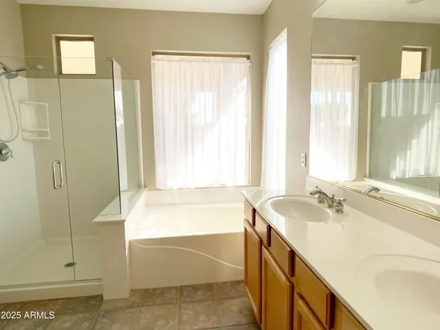 a spacious bathroom with a tub sink and mirror