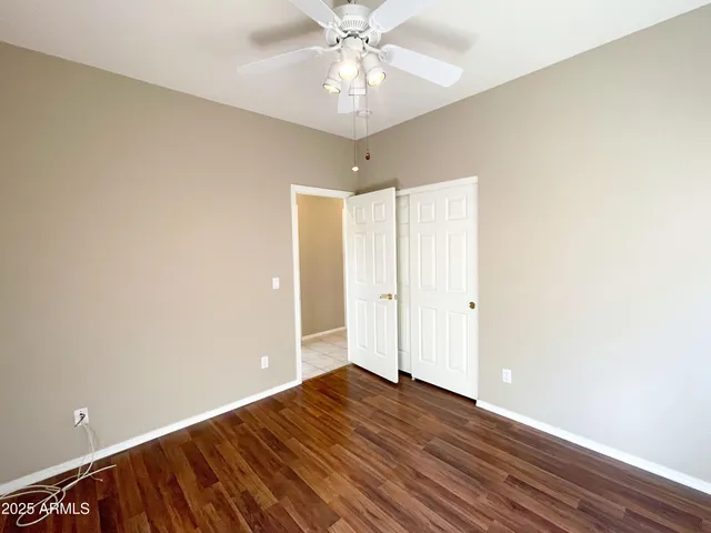 a view of a room with wooden floor and ceiling fan