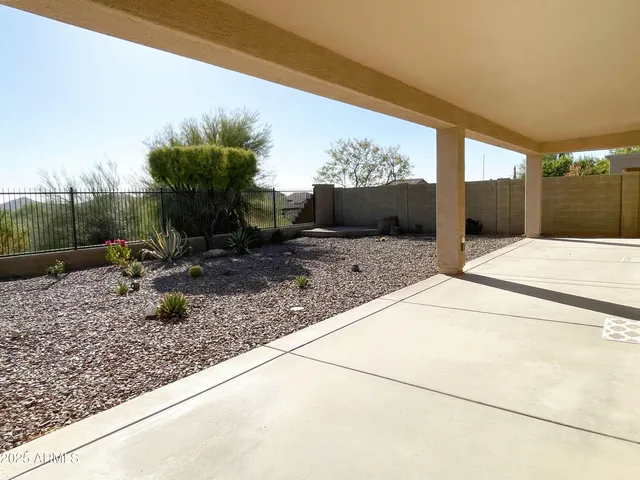 a view of a porch with couches potted plants and floor to ceiling window