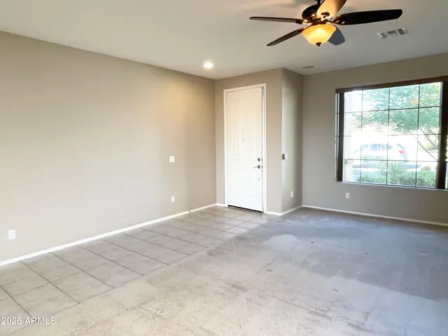 an empty room with windows and fan