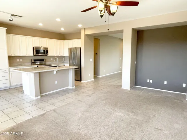 a view of kitchen with stainless steel appliances granite countertop a refrigerator and a stove top oven