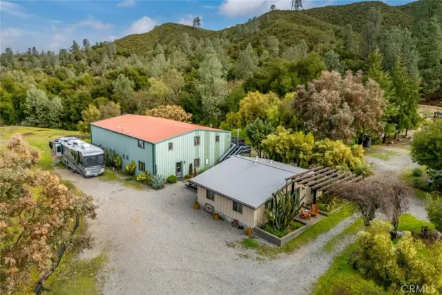 a living room with furniture and a dining table with kitchen appliances