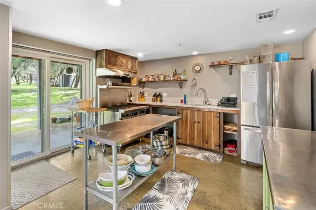 a view of a living room with furniture wooden floor windows and a chandelier