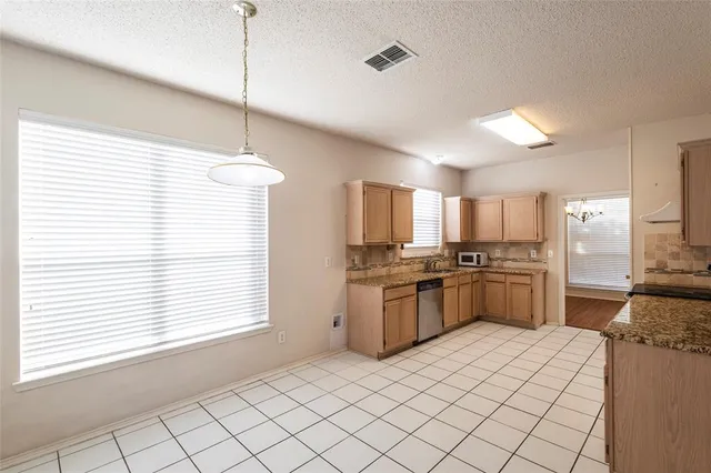 a kitchen with granite countertop a sink stove top oven and cabinets