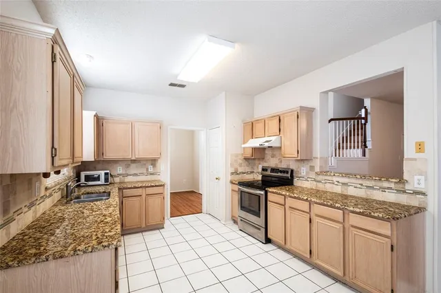a kitchen with a sink stove and cabinets