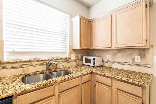 a kitchen with granite countertop a stove sink and cabinets