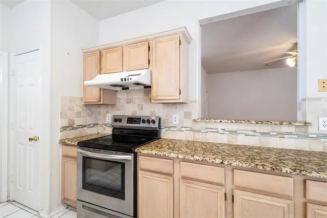 a kitchen with stainless steel appliances granite countertop a sink stove and cabinets