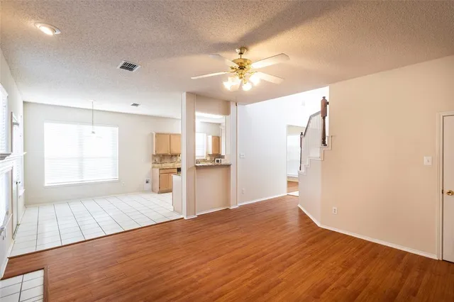 a view of a kitchen with wooden floor and a ceiling fan