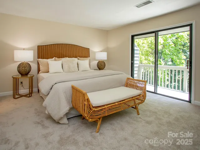 a bedroom with a bed and large windows