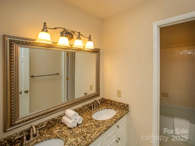 a bathroom with a granite countertop sink and a mirror
