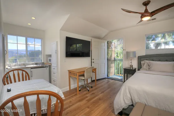 a bedroom with furniture and a flat screen tv
