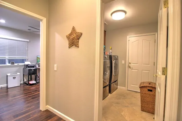 a view of a hallway with wooden floor and a living room