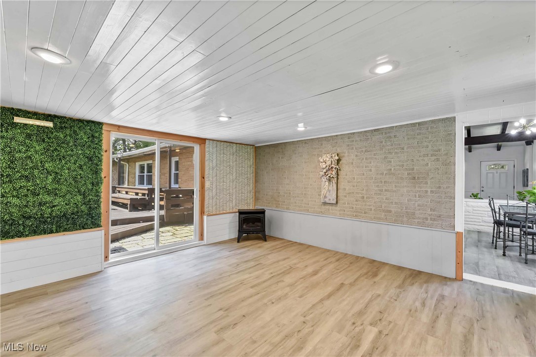 Alternate view of bonus room, vinyl plank flooring and white painted wood ceiling.