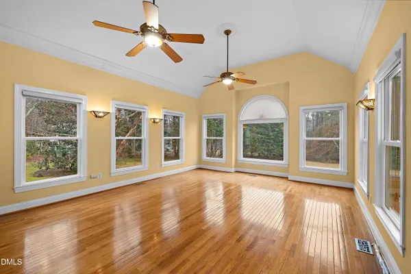 a view of an empty room with window and wooden floor