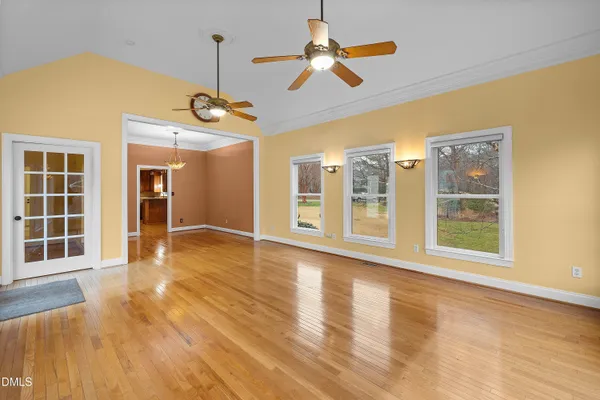 a view of an room with wooden floor fan and windows