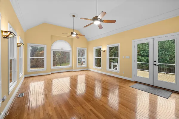 a view of empty room with wooden floor and window
