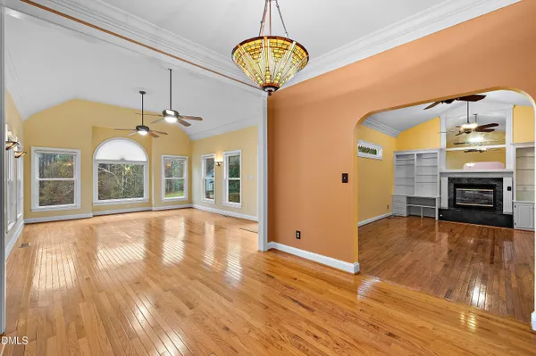 a kitchen with granite countertop a refrigerator a sink dishwasher a stove and a dining table with wooden floor