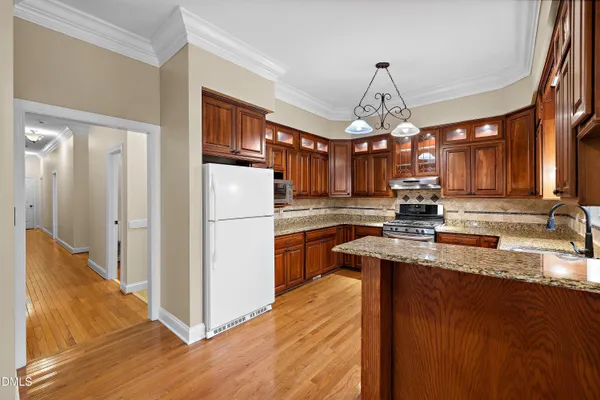 a kitchen with stainless steel appliances granite countertop wooden cabinets sink and stove top oven
