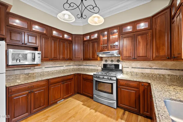 a open kitchen with stainless steel appliances granite countertop a stove granite counter tops and a view of living room