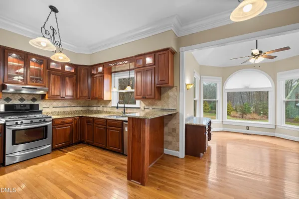 a kitchen with granite countertop wooden cabinets a refrigerator and a sink