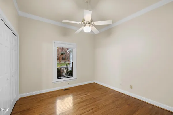 a view of a room with wooden floor and ceiling fan
