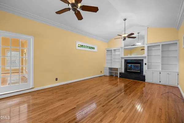a view of empty room with wooden floor