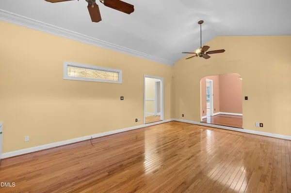a view of an empty room with a window and wooden floor