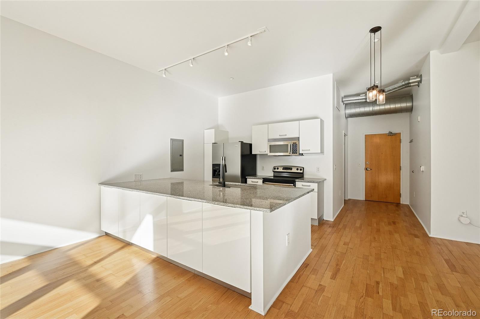 3100 Huron Street, Unit 2C Denver, CO 80202 - Photo 7 of 18 a large kitchen with stainless steel appliances a sink dishwasher a refrigerator a microwave oven with white cabinets and wooden floor